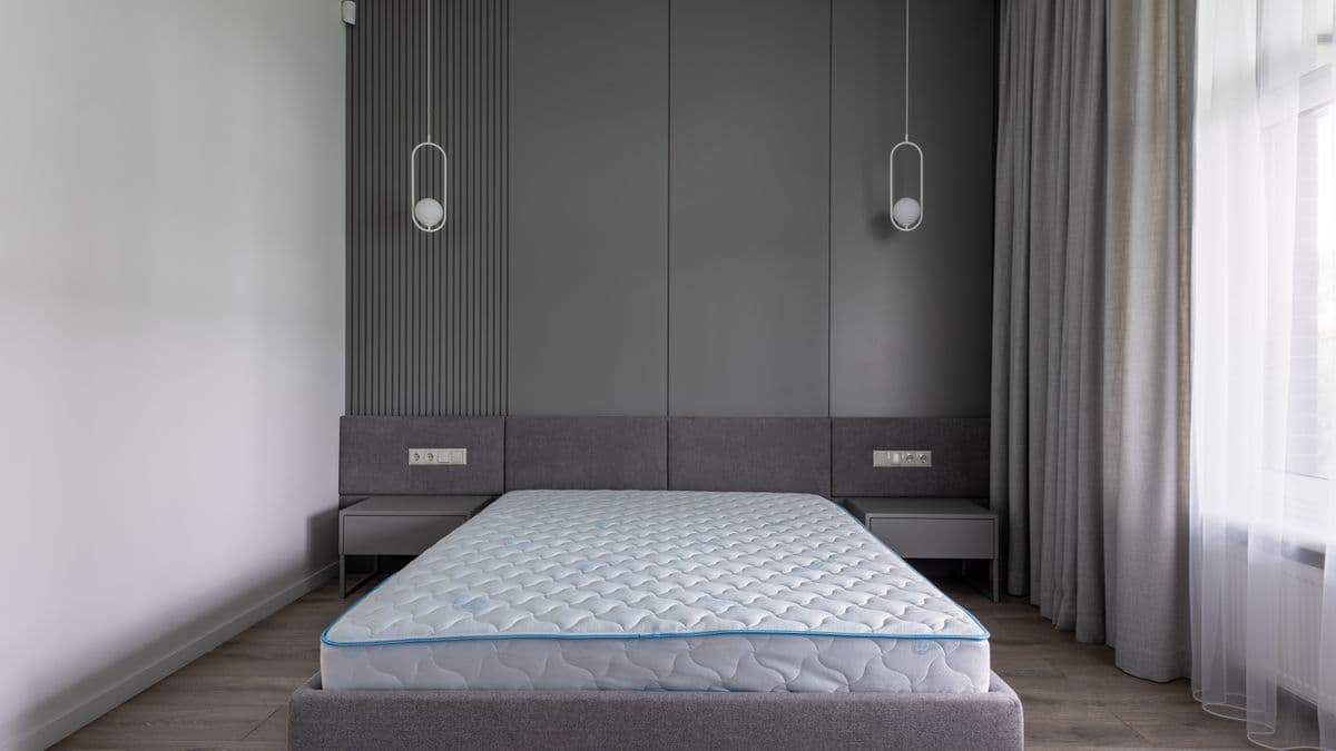 Cama com colchão limpo em quarto claro e arejado