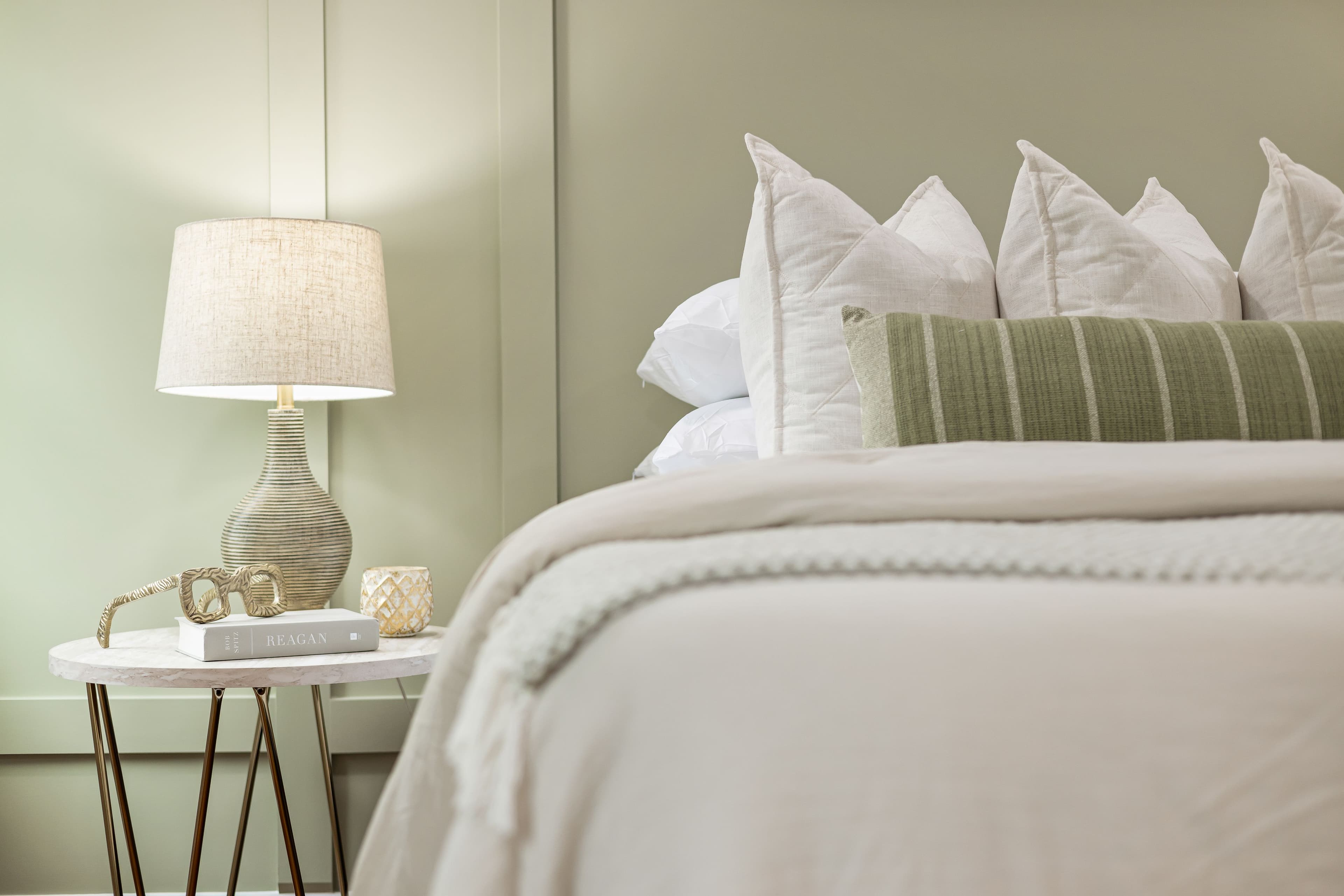 Quarto aconchegante com cama arrumada em tons claros